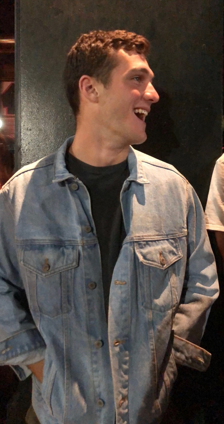 Drew laughing in a denim jacket